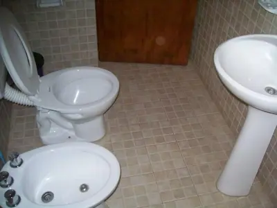 a bathroom with a toilet and a sink at Cabañas Alma Comechingon in Villa Cura Brochero