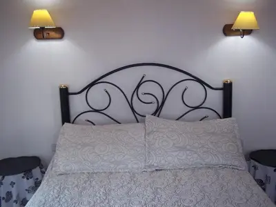 a bed with a metal headboard with two lights on it at Apart hotel Residencial El Puma in Mina Clavero
