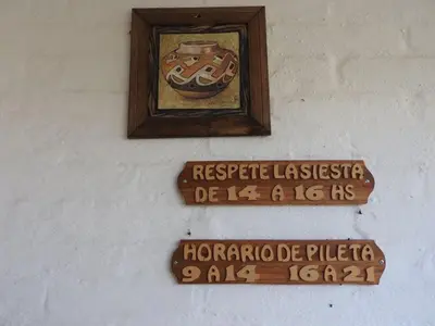 a wall with signs and a picture of a donut at Apart hotel Residencial El Puma in Mina Clavero