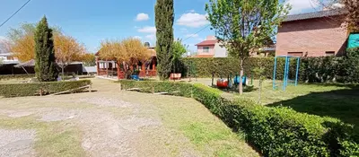a yard with a playground in front of a house at Apart hotel Residencial El Puma in Mina Clavero