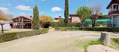 a large yard with a house and a building at Apart hotel Residencial El Puma in Mina Clavero