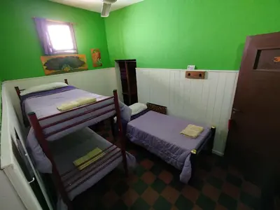 a green room with two bunk beds and a window at Andamundos Hostel in Mina Clavero