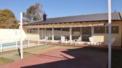 a large bird cage with white chairs in it at Duplex del Sol in Villa Carlos Paz
