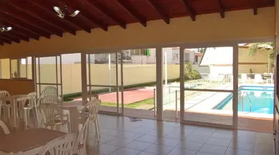 a room with a table and chairs and a pool at Duplex del Sol in Villa Carlos Paz