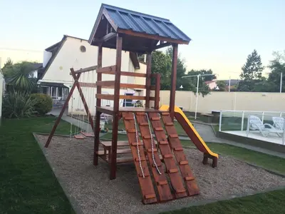 a wooden playground with a ladder and a slide at Duplex del Sol in Villa Carlos Paz
