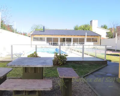 a group of picnic tables in front of a building at Duplex del Sol in Villa Carlos Paz