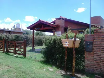 a house with a wooden fence and a fence at Cálidas Cabañas Las Piedras 2 , Villa Cura Brochero con wi fi in Villa Cura Brochero