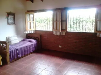 a bedroom with two windows and a bed in it at Cálidas Cabañas Las Piedras 2 , Villa Cura Brochero con wi fi in Villa Cura Brochero