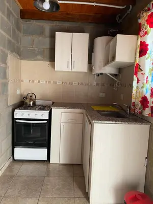 a small kitchen with white cabinets and a stove at Campos de Dios in Potrero de Garay