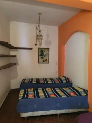 a bed in a room with an orange wall at Gimenoz Apart in Nono