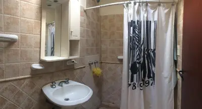 a bathroom with a sink and a shower curtain at Gimenoz Apart in Nono