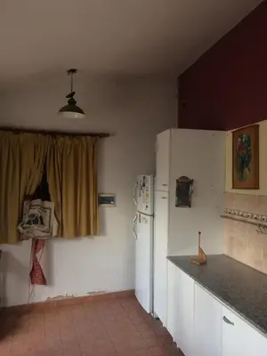 a kitchen with a refrigerator and a window at Gimenoz Apart in Nono