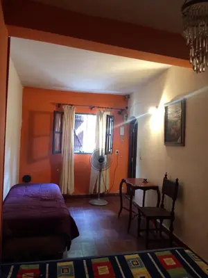 a bedroom with orange walls and a bed and a table at Gimenoz Apart in Nono