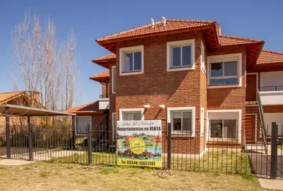 a house with a sign in front of it at Mirador Suites & Aptos in Villa General Belgrano
