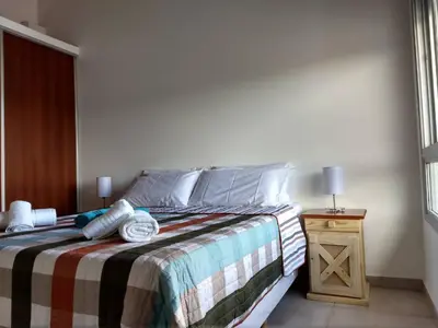a bedroom with a bed and a table with a window at Mirador Suites & Aptos in Villa General Belgrano