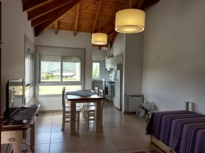 a kitchen with a table and chairs in a room at Mirador Suites & Aptos in Villa General Belgrano