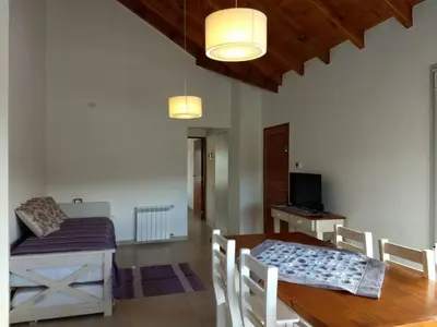 a dining room with a table and a table and chairs at Mirador Suites & Aptos in Villa General Belgrano