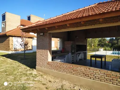 a brick pavilion with a patio in a yard at Mirador Suites & Aptos in Villa General Belgrano