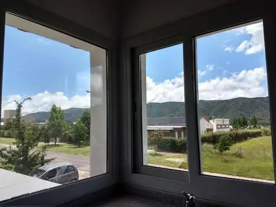 a room with three windows with mountains in the background at Mirador Suites & Aptos in Villa General Belgrano