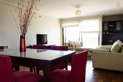 a living room with a table and red chairs at Departamento enorme sobre Cañada Patio Olmos in Cordoba