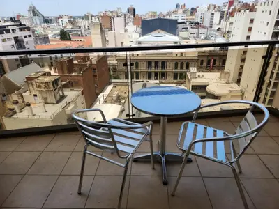 a table and chairs on a balcony with a view at Departamento enorme sobre Cañada Patio Olmos in Cordoba