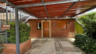an entrance to a brick building with a wooden door at Ariel Reynoso - Departamento Planta Baja in Mina Clavero