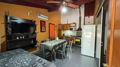 a kitchen with a table with chairs and a refrigerator at Ariel Reynoso - Departamento Planta Baja in Mina Clavero