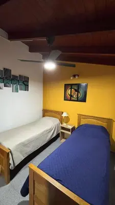 a bedroom with two beds and a yellow wall at Ariel Reynoso - Departamento Planta Baja in Mina Clavero