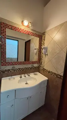 a bathroom with a white sink and a mirror at Ariel Reynoso - Departamento Planta Baja in Mina Clavero