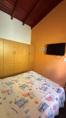 a bedroom with a bed and a tv on the wall at Ariel Reynoso - Departamento Planta Baja in Mina Clavero