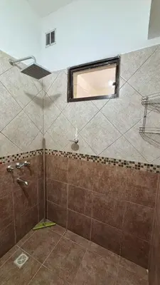 a bathroom with a shower with a window at Ariel Reynoso - Departamento Planta Baja in Mina Clavero