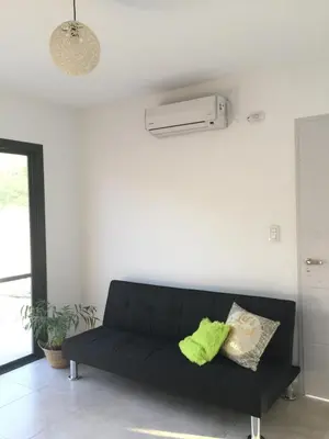 a black couch sitting in a living room at Alma Valiente in Merlo
