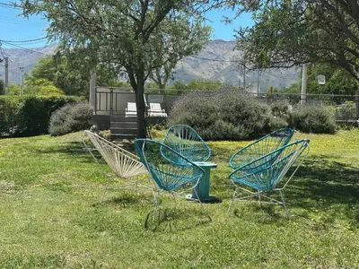 three blue chairs sitting in the grass in a park at Alma Valiente in Merlo