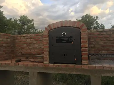 a brick oven with a door in a brick wall at Alma Valiente in Merlo