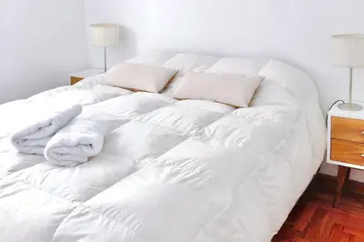 a white bed with white sheets and pillows at Ayres de Córdoba, Gran Terraza, Excelente Ubicación in Cordoba