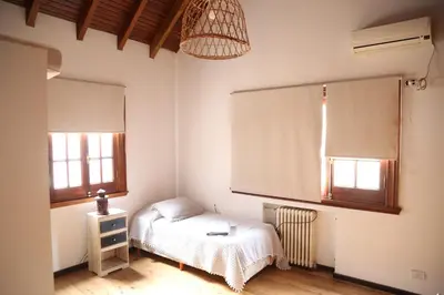 a small bedroom with a bed and two windows at Casa en Córdoba in Cordoba