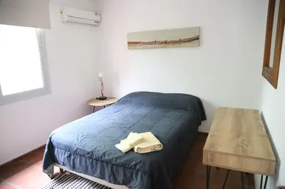 a small bedroom with a bed and a table at Casa en Córdoba in Cordoba