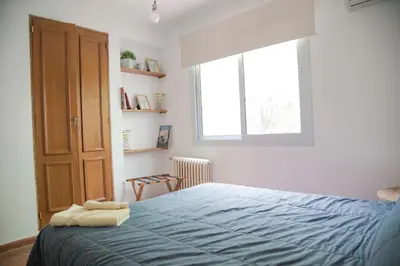 a bedroom with a bed with blue sheets and a window at Casa en Córdoba in Cordoba