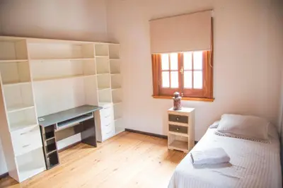 a bedroom with a bed and a desk and a window at Casa en Córdoba in Cordoba