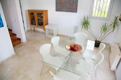 a dining room with a glass table and white chairs at Casa en Córdoba in Cordoba