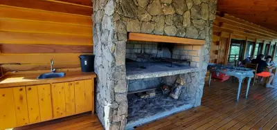 a large stone fireplace in a log cabin at Complejo Apus in La Cumbrecita