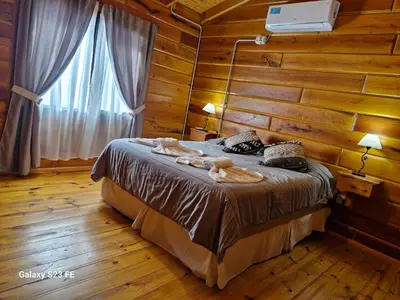 a bedroom with a bed in a wooden room at Complejo Apus in La Cumbrecita