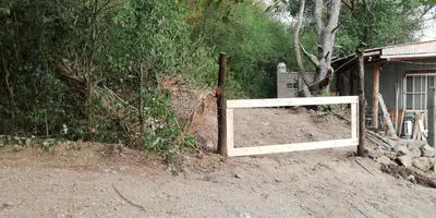 a wooden gate in the dirt next to a house at Las zarinas 1 in Trapiche