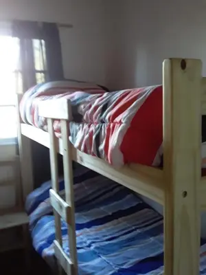 a bunk bed with a red pillow on it at Las zarinas 2 in Trapiche