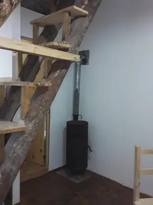 a wood stove in a room with wooden stairs at Las zarinas 2 in Trapiche
