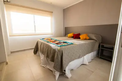 a bedroom with a bed with a blanket on it at Hotel Las Piedras in Villa Cura Brochero