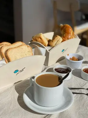 a table topped with a cup of coffee and bread at Hotel Las Piedras in Villa Cura Brochero