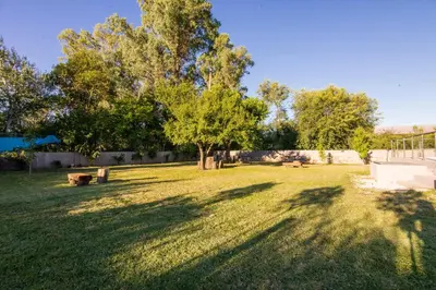 a green yard with a tree and a fence at Hotel Las Piedras in Villa Cura Brochero