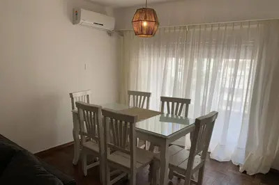 a dining room with a table and chairs and a window at Departamento en Nueva Cordoba, 2 dormitorios in Cordoba