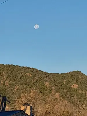 a moon in the sky over a mountain at El mirador de estrellas in Santa Rosa de Calamuchita